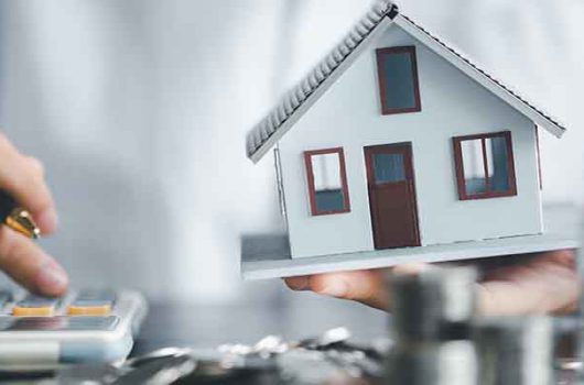 Saving investment home with loan finance money business concept. Investment banking finance for residential real estate business. Stack coins with model house for investment loans.Cash for taxes.