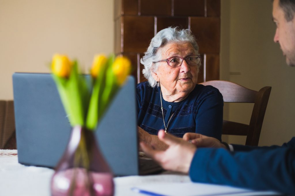 Senior lady making a contract with lawyer, using laptop while doing so