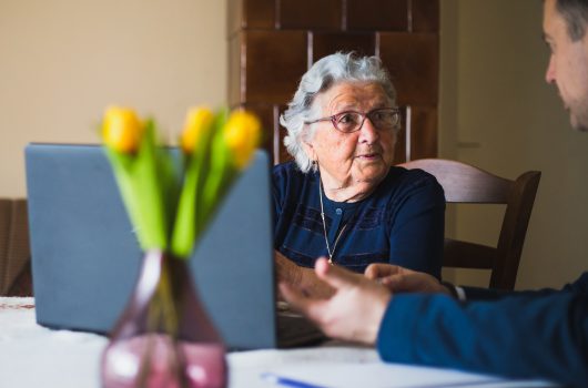 Senior lady making a contract with lawyer, using laptop while doing so